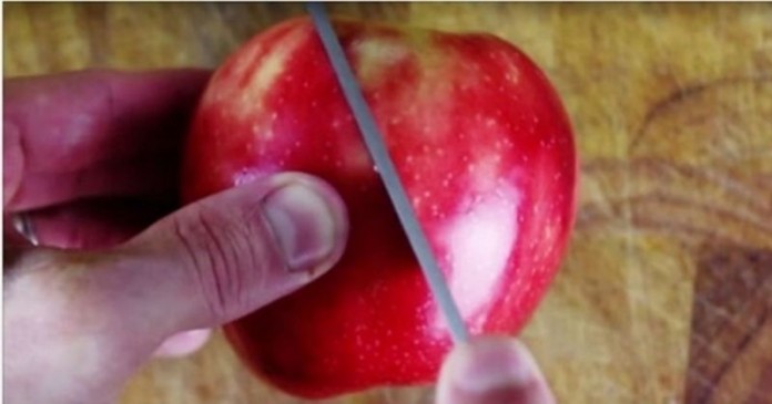 Αρχίζει να κόβει το μήλο με το μαχαίρι διαγώνια. Το αποτέλεσμα θα εντυπωσιάσει τους καλεσμένους σας!